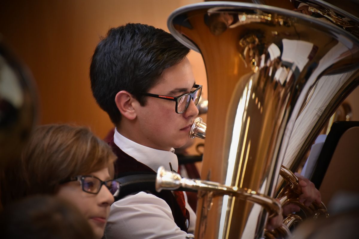 A male dressed nicely playing the tuba in an Orchestra